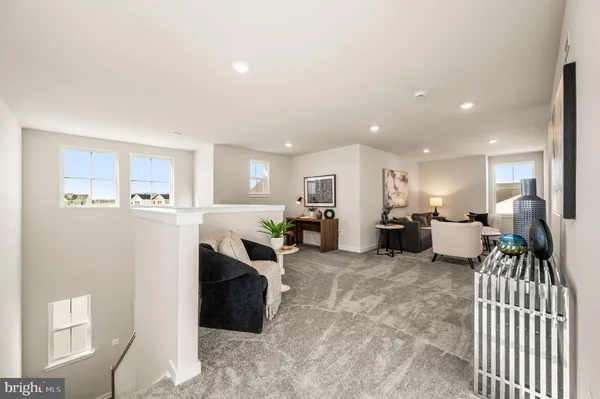 a living room with furniture a table and kitchen view