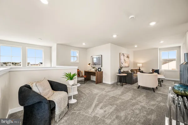 a living room with furniture kitchen view and a potted plant