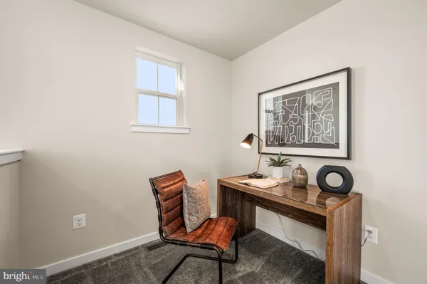 a view of a workspace with furniture and window