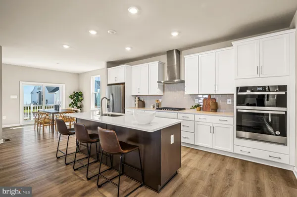 a kitchen with stainless steel appliances granite countertop a stove a sink a microwave a center island and cabinets