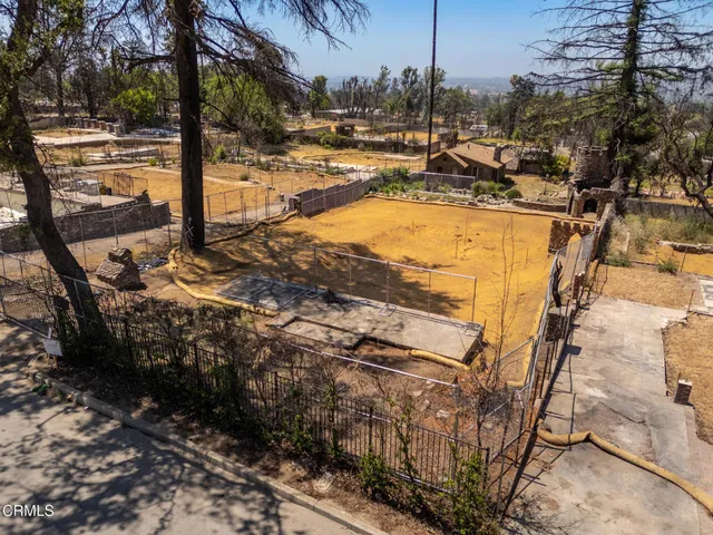 a view of a backyard with wooden fence