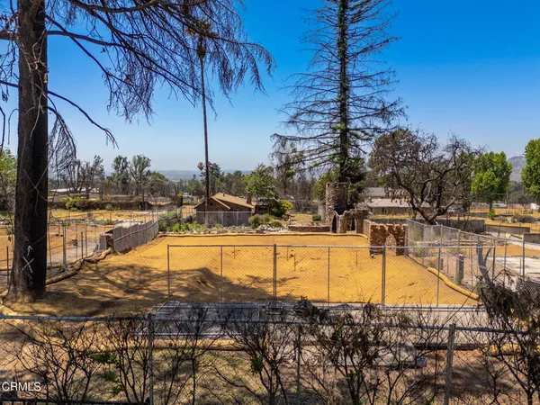 a view of a yard with wooden fence