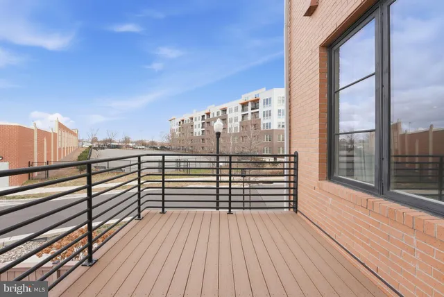 a view of a balcony with wooden floor and iron stairs