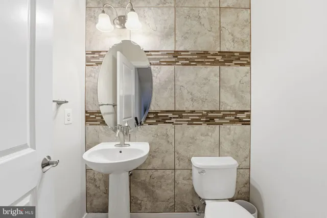 a bathroom with a toilet sink and mirror