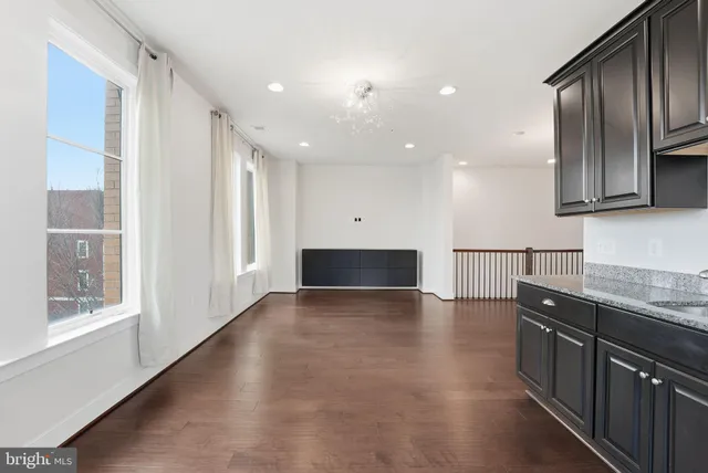 a view of a kitchen with a sink and dishwasher a oven with wooden floor