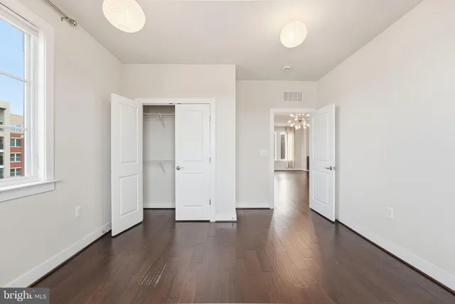 an empty room with wooden floor and a window