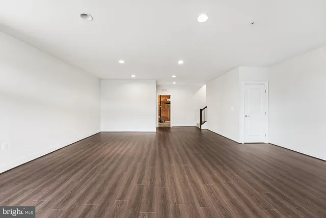 a view of empty room with wooden floor and window