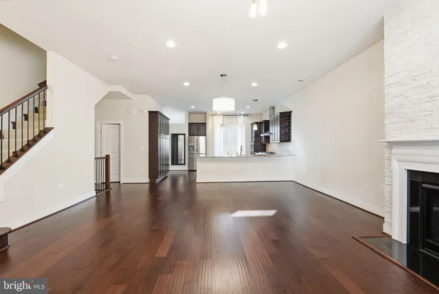 a view of a big room with wooden floor and a kitchen