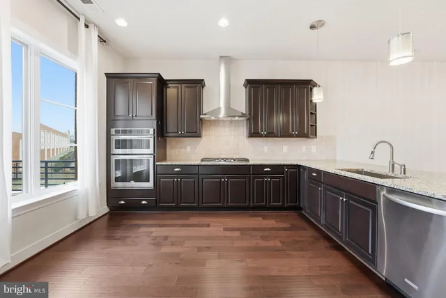 a kitchen with stainless steel appliances granite countertop a stove a sink and a refrigerator