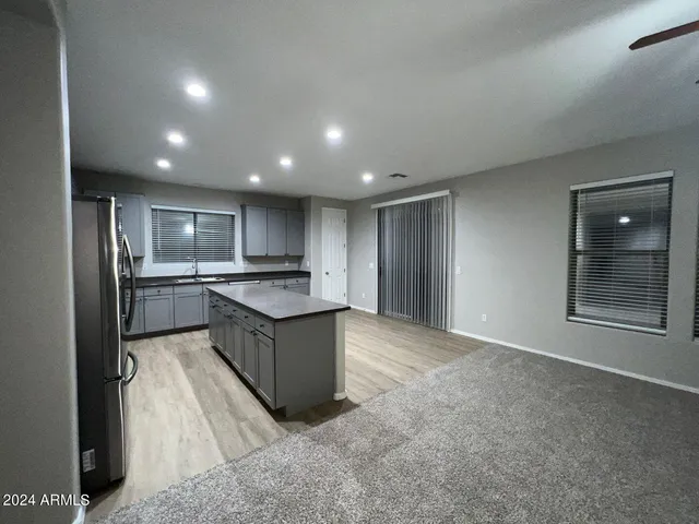 a large kitchen with a large counter top stainless steel appliances and cabinets