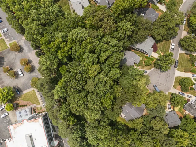 an aerial view of residential house with outdoor space and trees all around