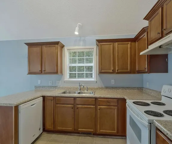 a kitchen with granite countertop a sink and a stove