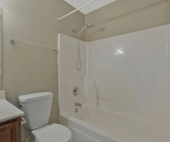 a white toilet sitting next to a bath tub