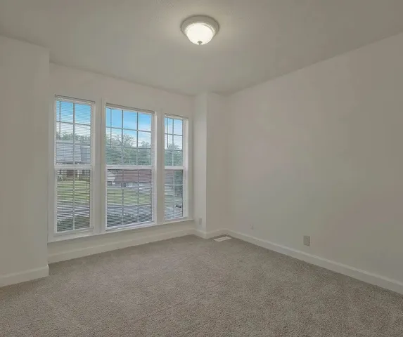 an empty room with windows and closet