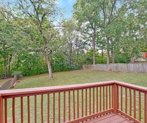 a view of backyard with green field and trees