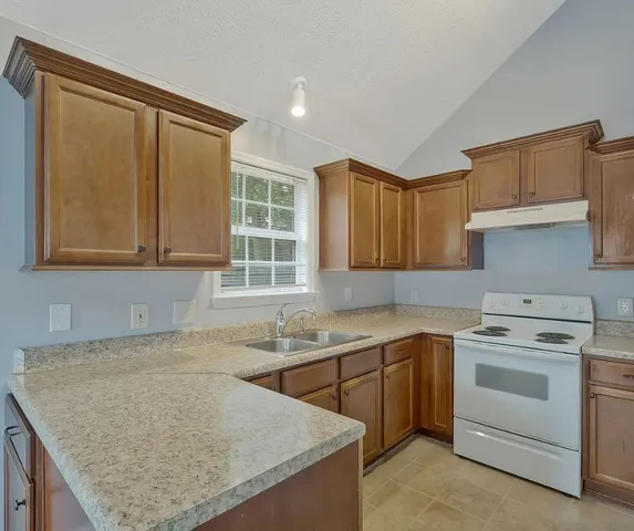 a kitchen with a sink stove and cabinets