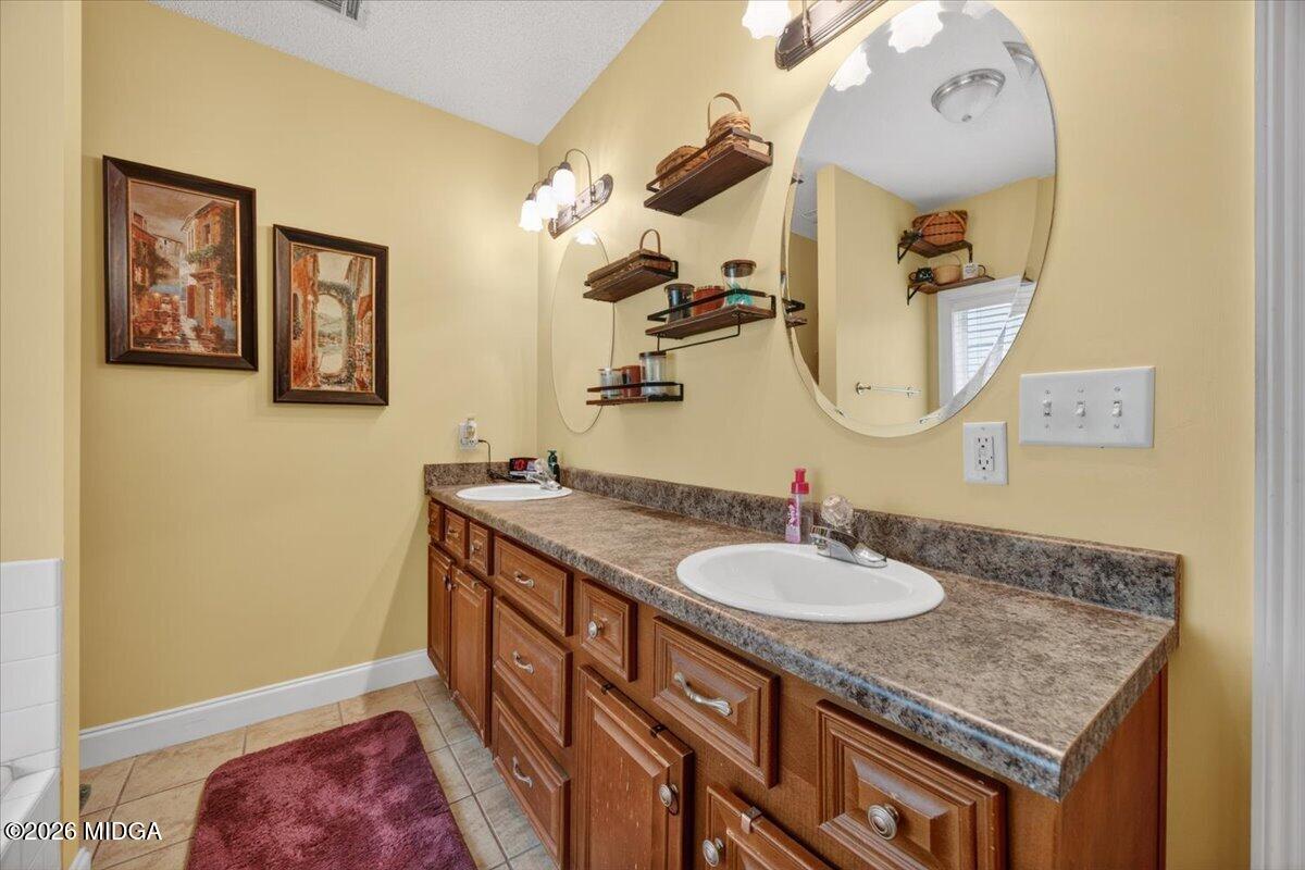 619 Grayridge Road Gray, GA 31032 - Photo 22 of 40 a bathroom with a granite countertop sink a mirror and vanity