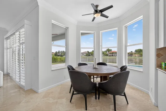 a large white kitchen with stainless steel appliances kitchen island granite countertop a sink and a refrigerator