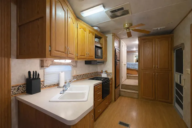 a kitchen with stainless steel appliances granite countertop a sink a stove and a refrigerator