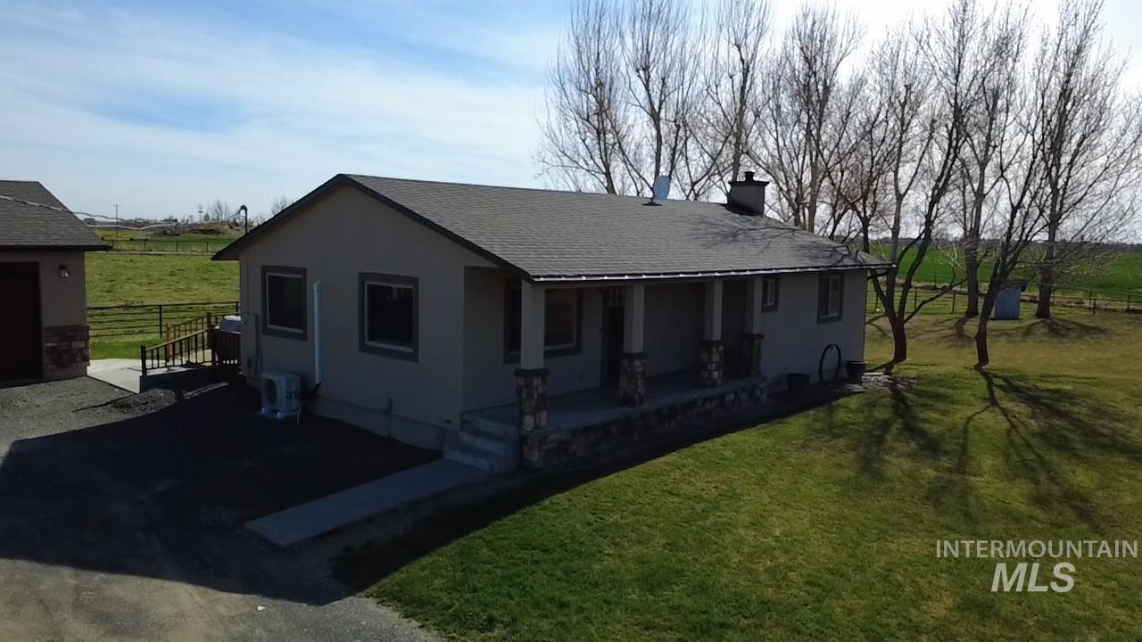2155 East 1775 South Gooding, ID 83330 - Photo 1 of 18 View of front of property featuring a view of countryside, roof with shingles, a chimney, stucco siding, and a patio area