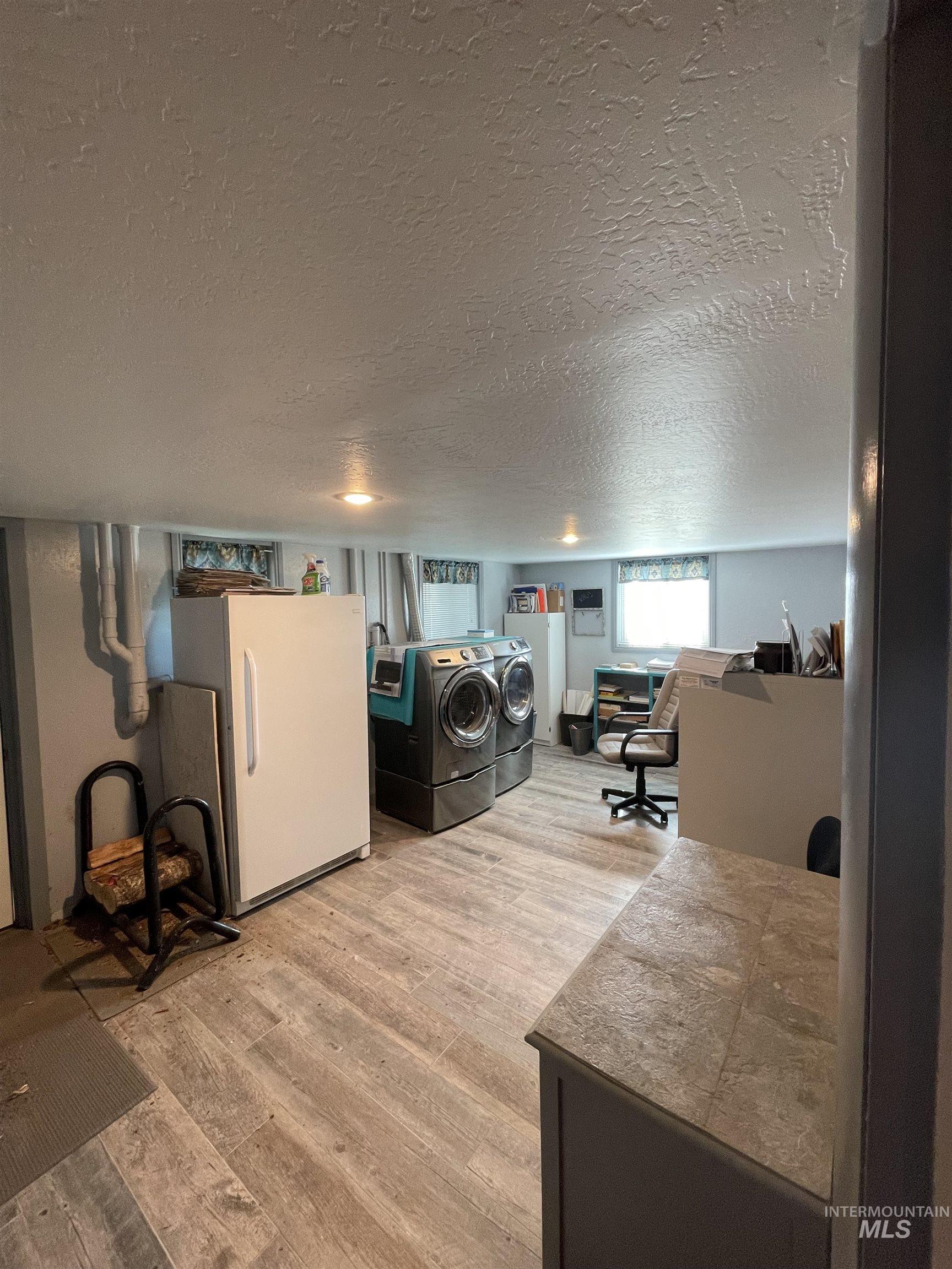2155 East 1775 South Gooding, ID 83330 - Photo 11 of 18 Laundry area featuring a textured ceiling, light wood finished floors, and washing machine and clothes dryer