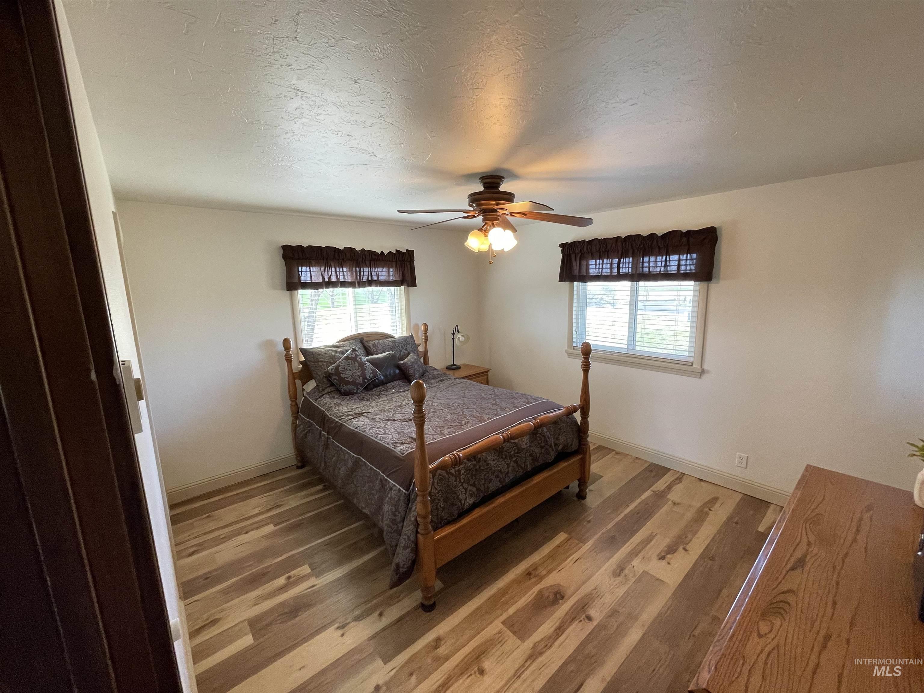 2155 East 1775 South Gooding, ID 83330 - Photo 4 of 18 Bedroom featuring multiple windows, ceiling fan, wood finished floors, and a textured ceiling