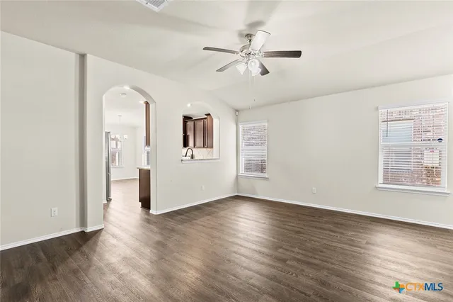 a view of a livingroom with wooden floor and a ceiling fan