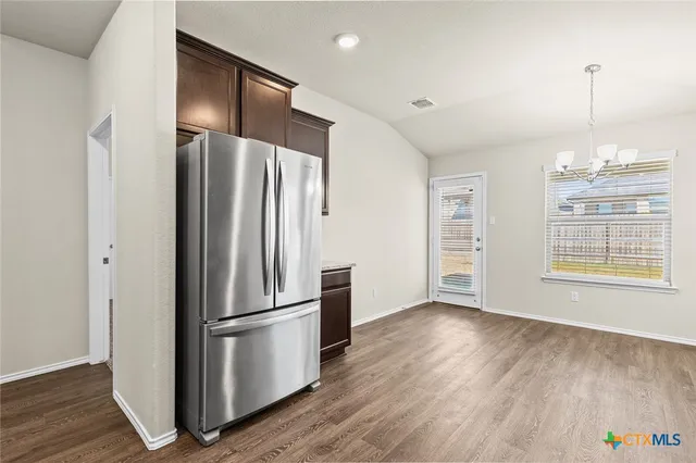 a kitchen with stainless steel appliances a refrigerator and wooden floor