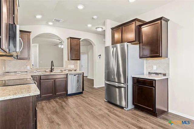a kitchen with stainless steel appliances granite countertop a stove microwave and sink