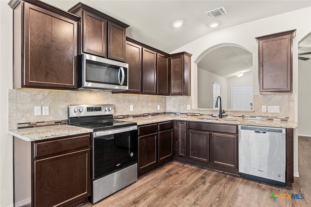256 Bainbridge Road Temple, TX 76502 - Photo 16 of 40 a kitchen with stainless steel appliances granite countertop a stove microwave and sink