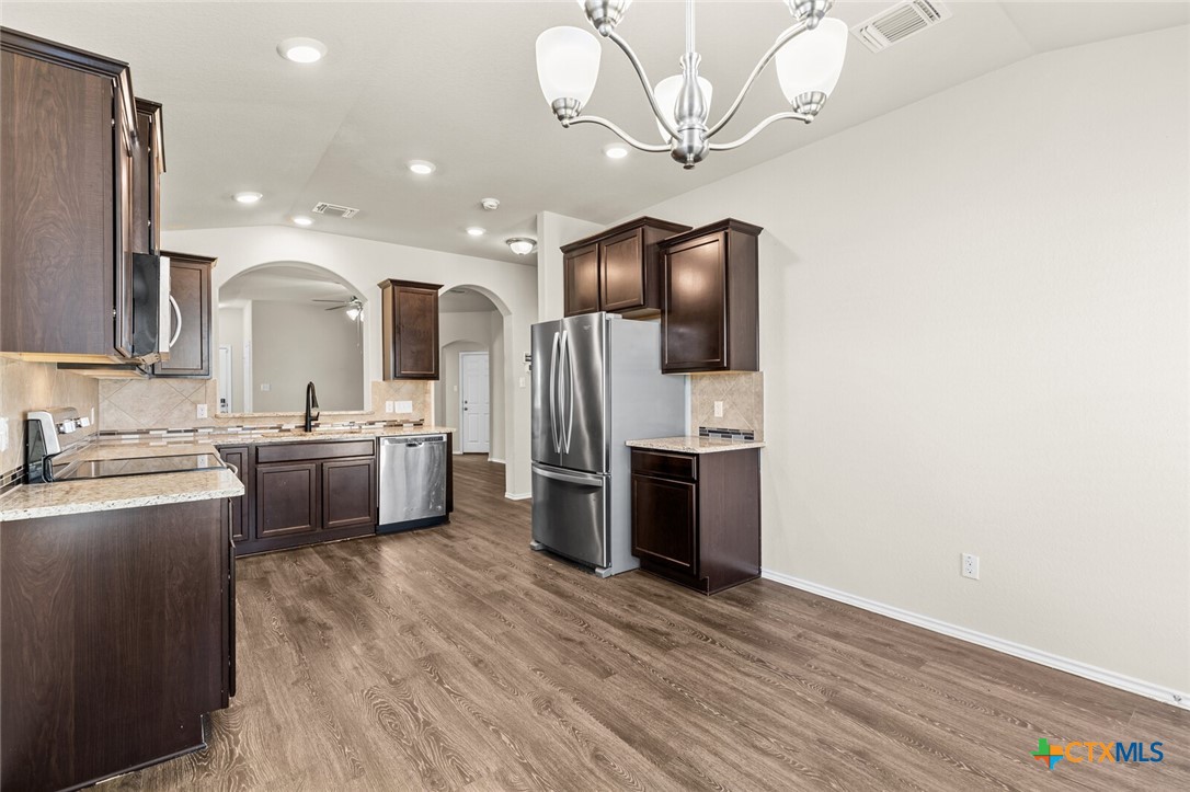 256 Bainbridge Road Temple, TX 76502 - Photo 18 of 40 a kitchen with stainless steel appliances a sink cabinets and wooden floor