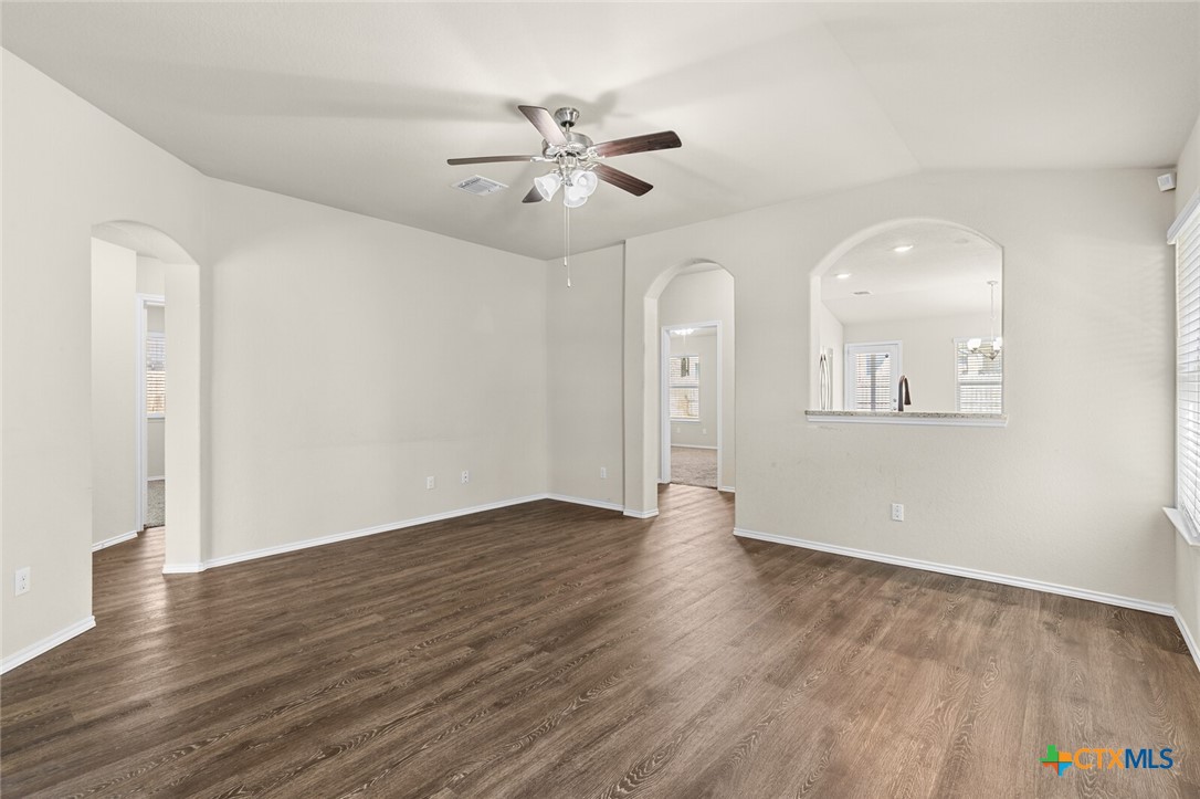 256 Bainbridge Road Temple, TX 76502 - Photo 9 of 40 an empty room with wooden floor chandelier fan and windows