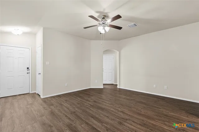 a view of an empty room with wooden floor