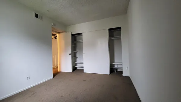 an empty room with closet and a window