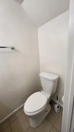 a white toilet sitting next to a white sink and vanity