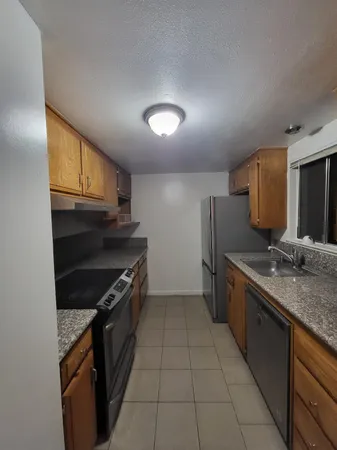 a kitchen with stainless steel appliances granite countertop a stove a sink and a refrigerator