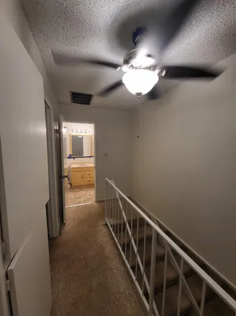 a view of a hallway with wooden floor and chandelier
