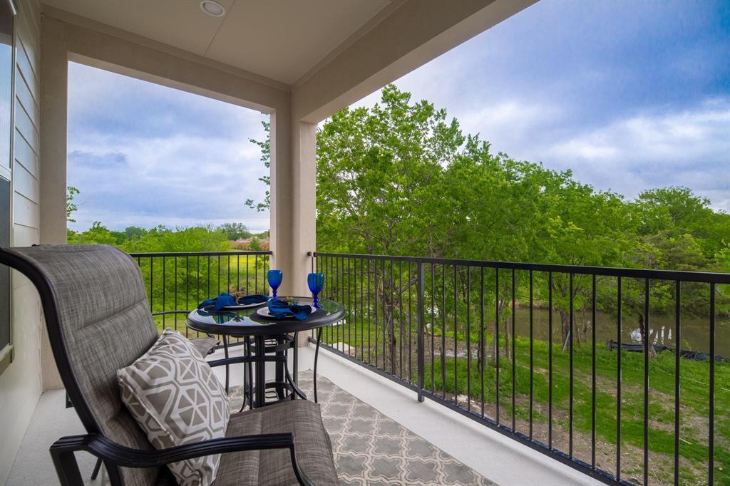 770 North Plano Road, Unit 303 Richardson, TX 75081 - Photo 20 of 26 The property features a balcony with a black metal railing and views of lush green trees and a body of water