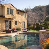 a patio with table and chairs and potted plants