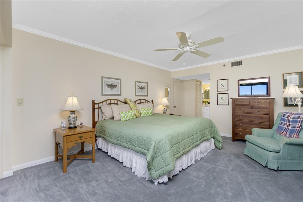 1651 Beach Road, Unit 301 Englewood, FL 34223 - Photo 25 of 68 a spacious bedroom with a bed and a chandelier