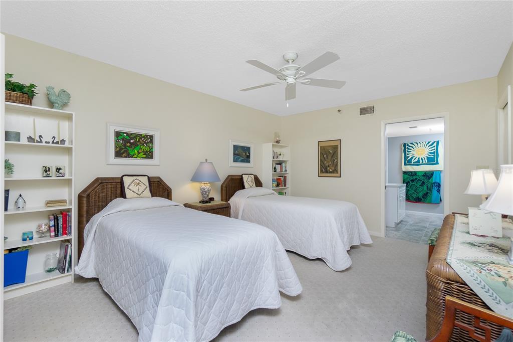 1651 Beach Road, Unit 301 Englewood, FL 34223 - Photo 32 of 68 a spacious bedroom with two beds and a chandelier