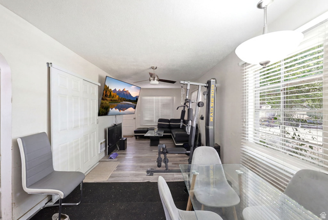 5480 South 2000th Street West Roy, UT 84067 - Photo 14 of 36 Open concept room featuring wood-finish flooring, white walls, and a ceiling fan
