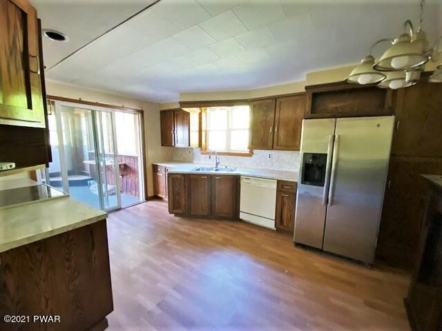 93 Miller Road Beach Lake, PA 18405 - Photo 13 of 53 a kitchen with stainless steel appliances granite countertop a refrigerator a sink dishwasher a stove and a dining table with wooden floor