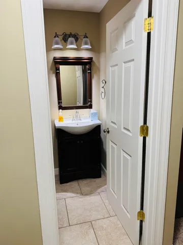 a bathroom with a sink and mirror with bathtub