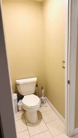 a white toilet sitting next to a white wall