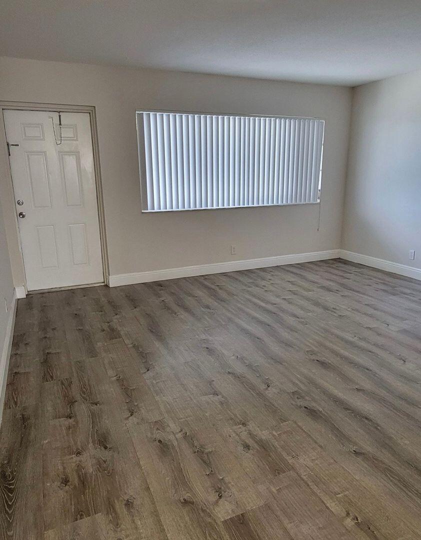 2711 Vandiver Drive, Unit 307 West Palm Beach, FL 33409 - Photo 4 of 15 a view of a room with wooden floor and windows