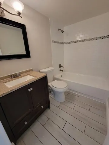 a bath room with a toilet a sink and a mirror