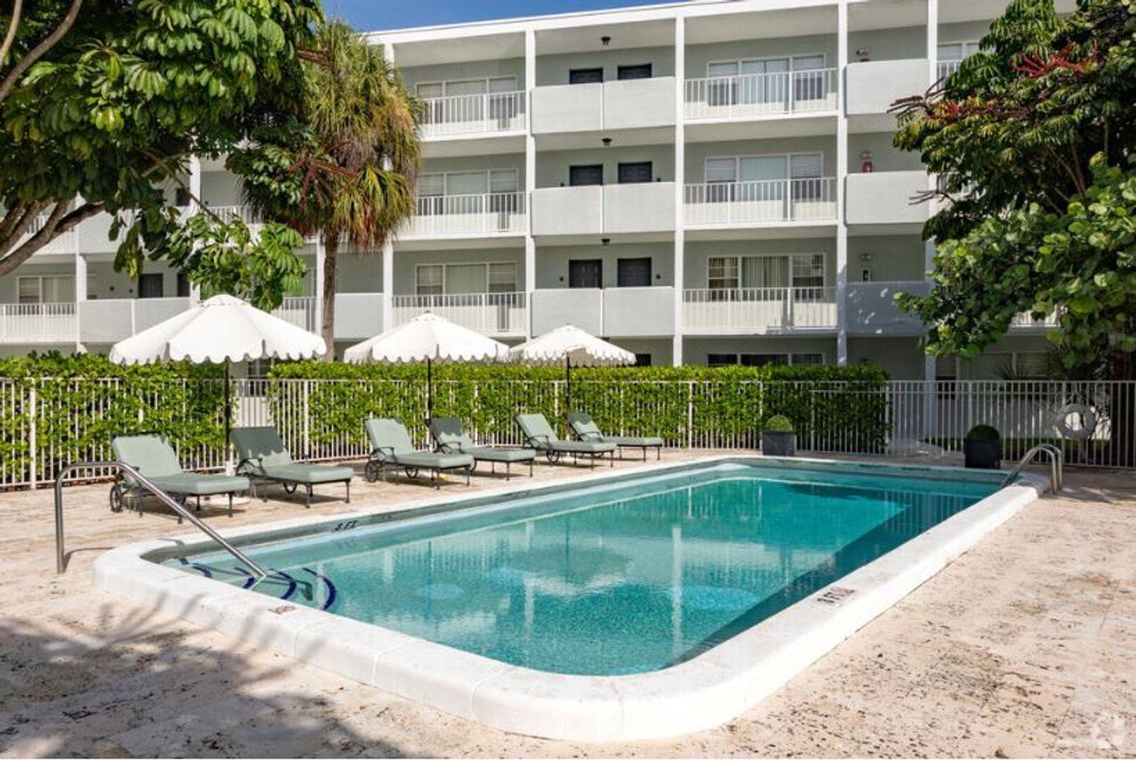 2711 Vandiver Drive, Unit 307 West Palm Beach, FL 33409 - Photo 7 of 15 a view of a swimming pool with a lounge chairs