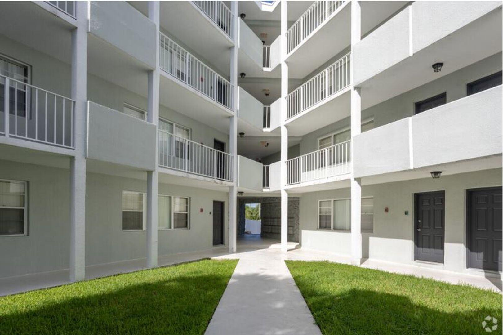 2711 Vandiver Drive, Unit 307 West Palm Beach, FL 33409 - Photo 10 of 15 a view of an apartment with many windows and a yard