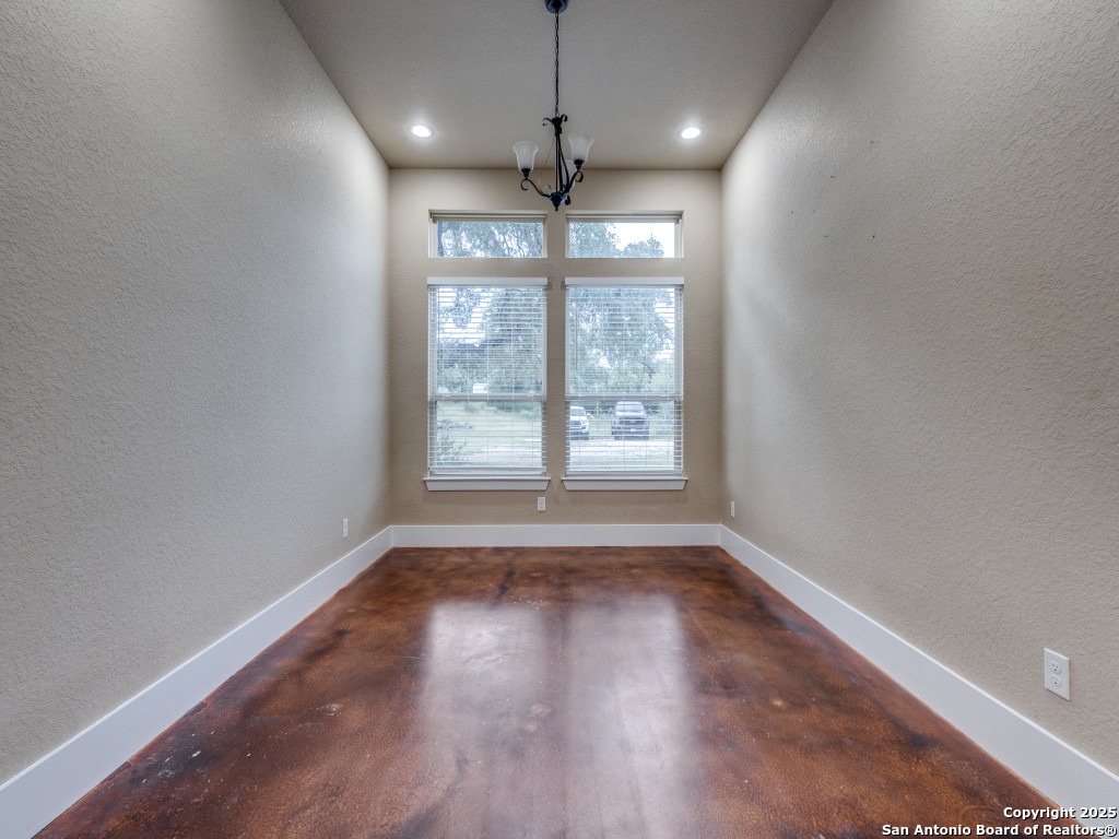 629 Windmill Ranch Road Spring Branch, TX 78070 - Photo 16 of 34 a view of an empty room with wooden floor and a window